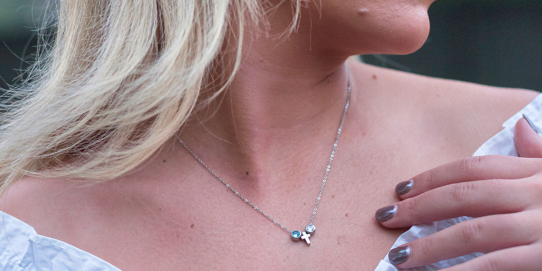 silver charm necklace with cross and blue gems