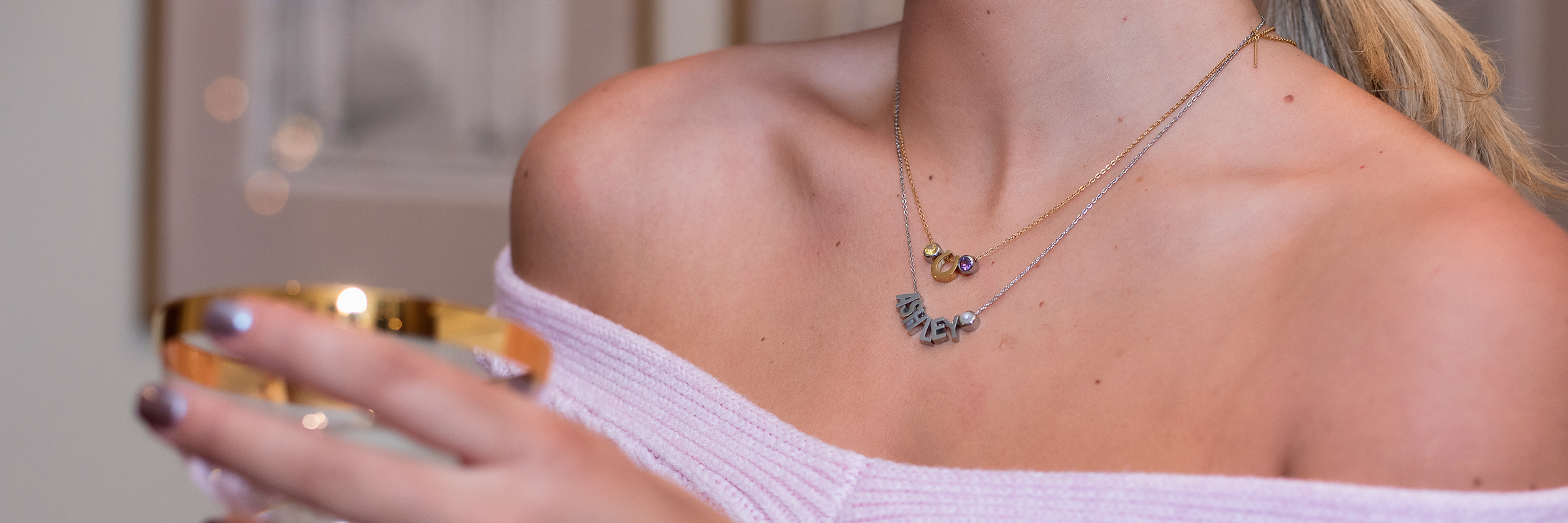 silver name necklace stacked with a horseshoe charm necklace